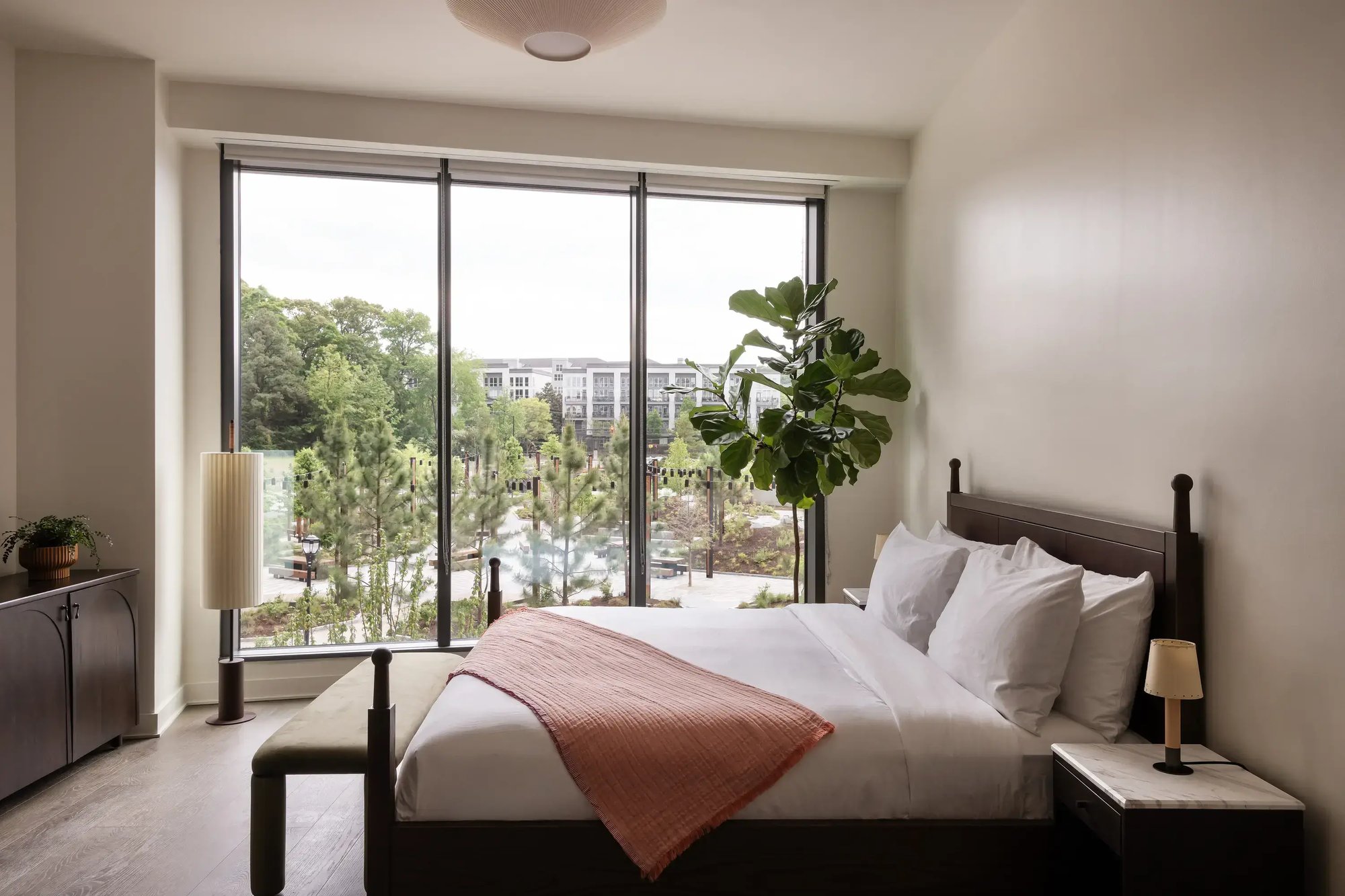 Suite bedroom with floor-to-ceiling windows over the treetops